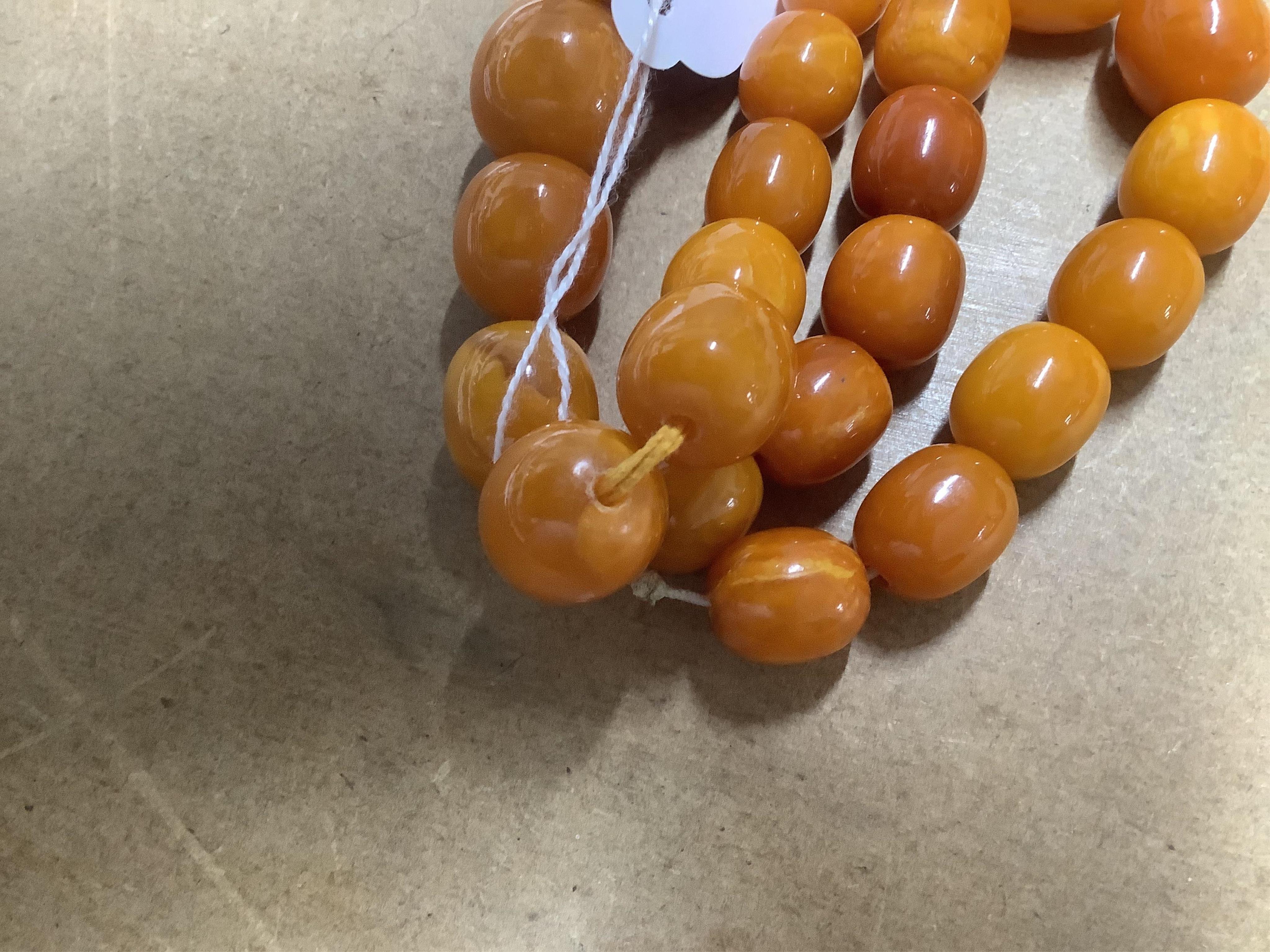 A single strand graduated amber bead necklace, 70cm, gross weight 67 grams, together with an amber bead bracelet, gross weight 20 grams. Condition - poor to fair